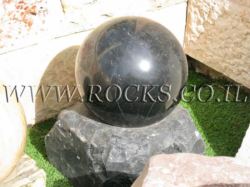 כדור סלע שחור מזרקה מסתובב במים כפר הסלעים המים זורמים דרך האבן לסלע הישר למשאבה